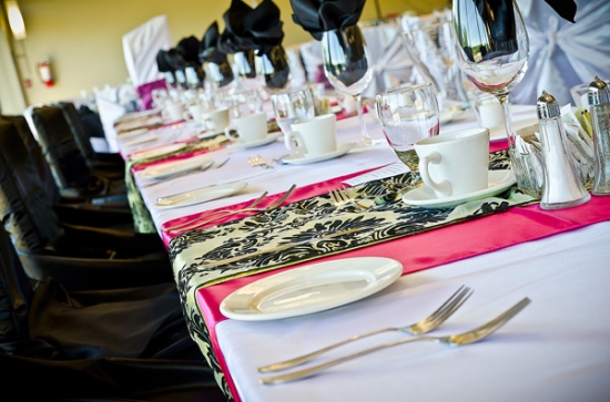Elegant wedding reception table setting with pink and black accents