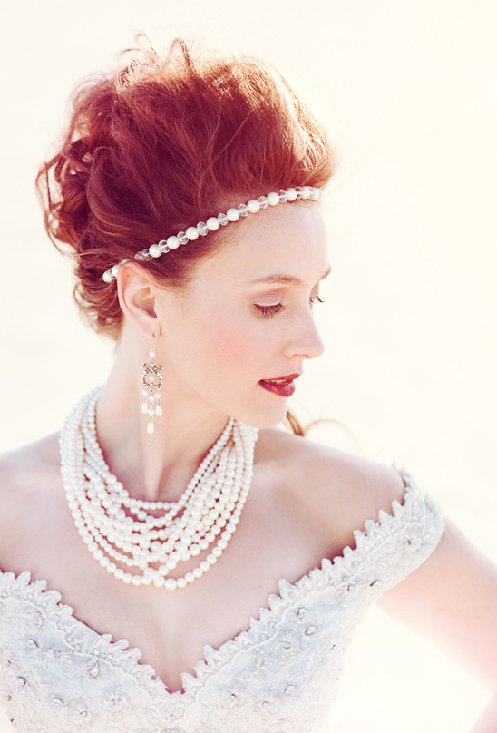 Red haired bride in pearl jewelry and white gown