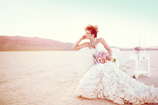 Bride in wedding dress poses in desert landscape