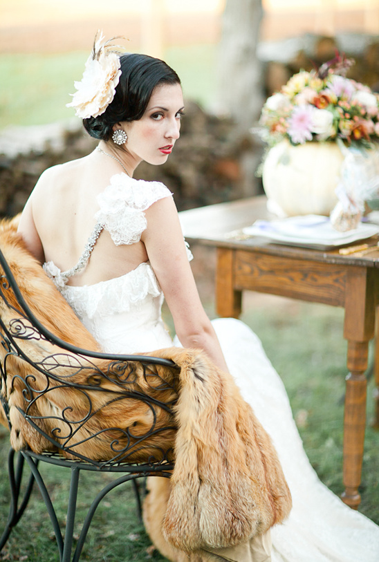 Vintage style bride in gown with fur stole on chair
