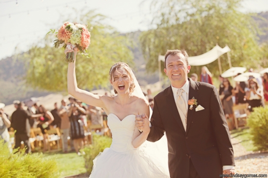 Happy bride and groom celebrate at outdoor wedding