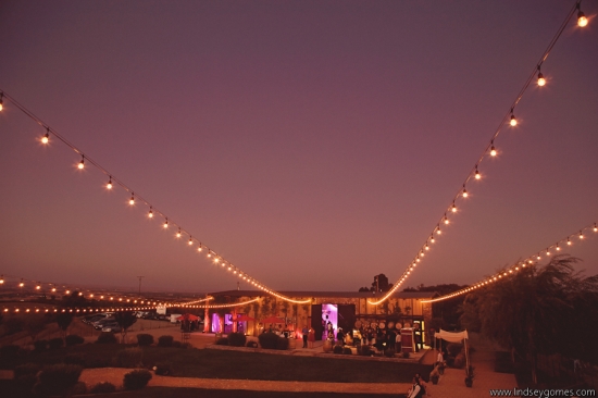 Twilight wedding reception under string lights landscape