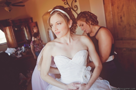 Bride getting dressed in wedding dress