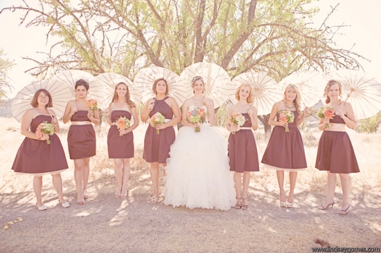 Wedding party in maroon dresses under parasols