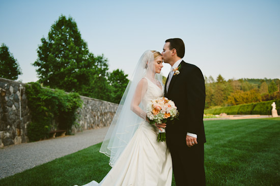 Groom kisses bride on forehead wedding day