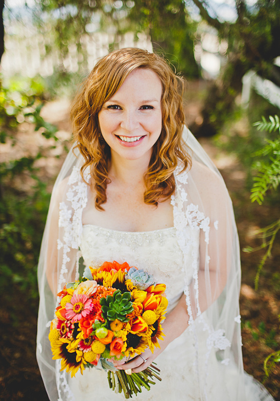Smiling bride holding vibrant sunflowers wedding bouquet