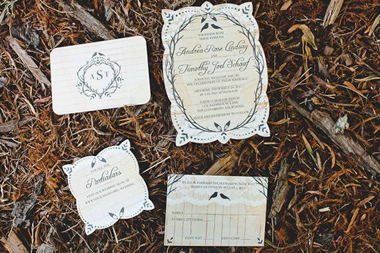 Rustic wedding invitation cards on ground