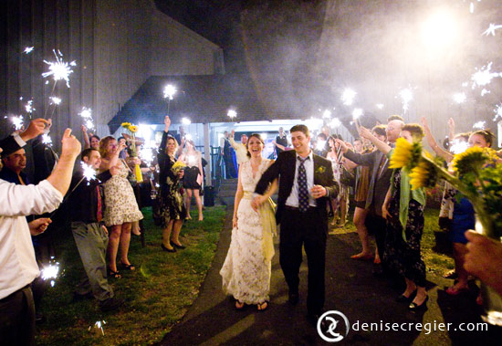Happy couple exits wedding reception with sparklers