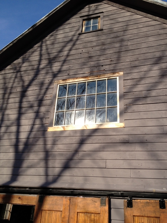 Gray barn with windows and sliding wooden doors