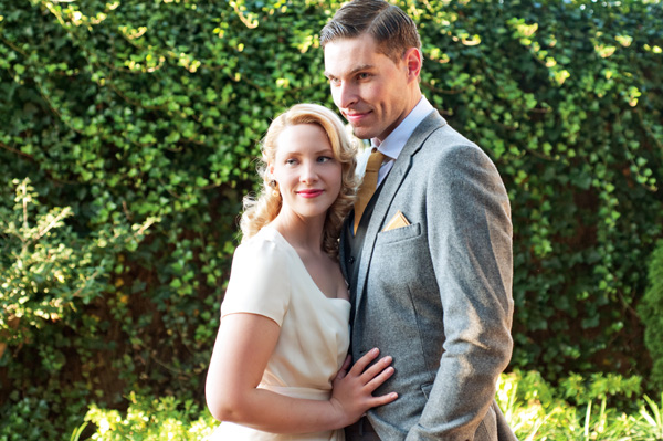 Happy couple in vintage attire embracing outdoors