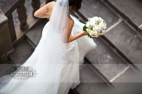 Bride descending stairs, holding bouquet