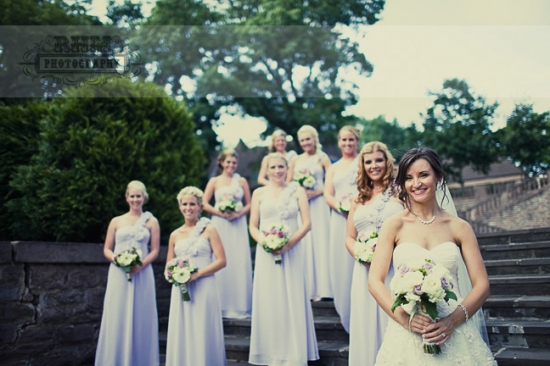 Bride with bridesmaids in lavender dresses on stairs