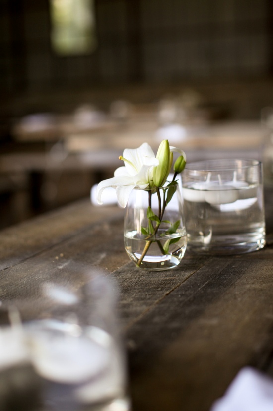 Wedding reception table setting with lilies and candles