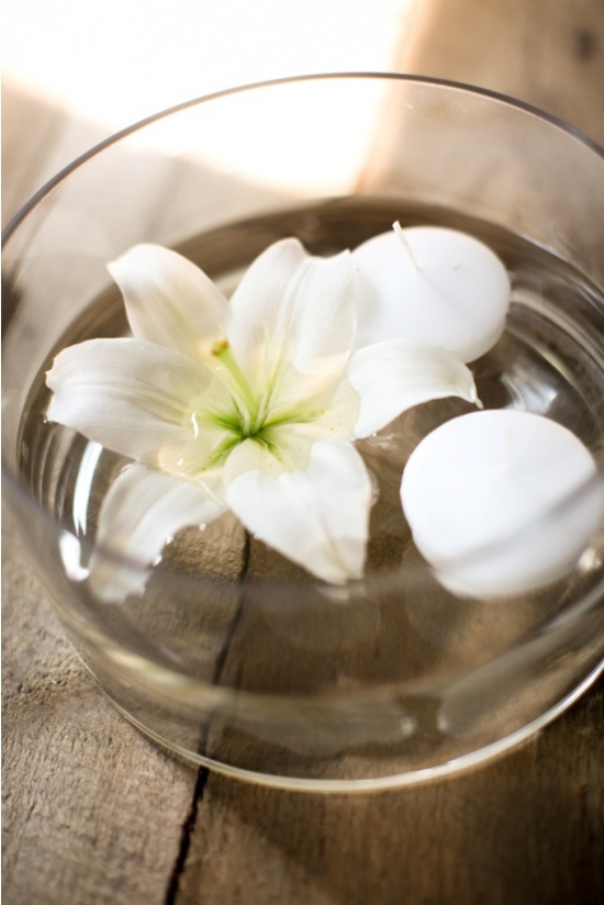 White lily and floating candles in a glass bowl