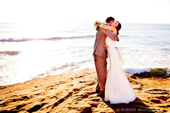 Happy couple embracing on a beach at sunset