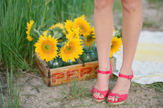 Woman in pink heels near sunflowers in crate