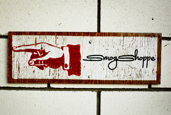 Hand points to Smog Shoppe sign