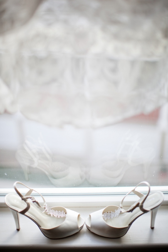Elegant white wedding shoes on windowsill