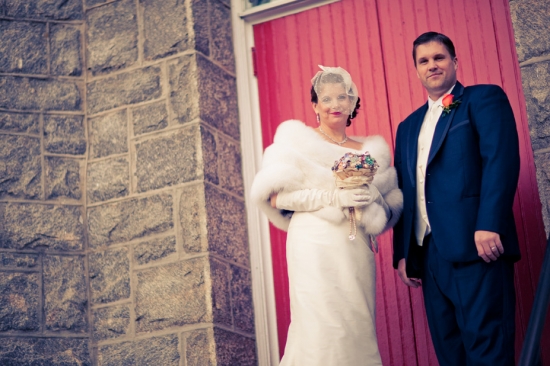 Couple in wedding attire at red door