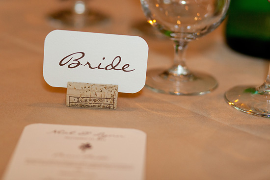 Bride place card held by wine cork at wedding reception