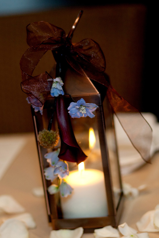 Floral adorned lantern with candle and ribbon bow