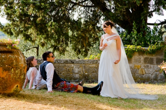 Bride and guests relax by a stone wall
