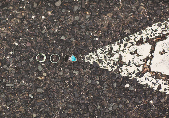 Wedding rings on asphalt with turquoise stone ring