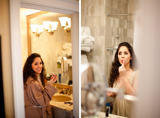 Bride applying makeup in hotel bathroom mirror