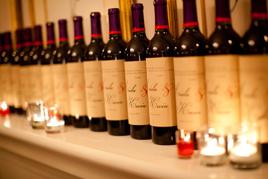 Line of personalized wedding wine bottles with candlelight