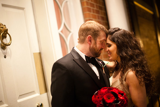 Newlyweds share a tender moment with red roses