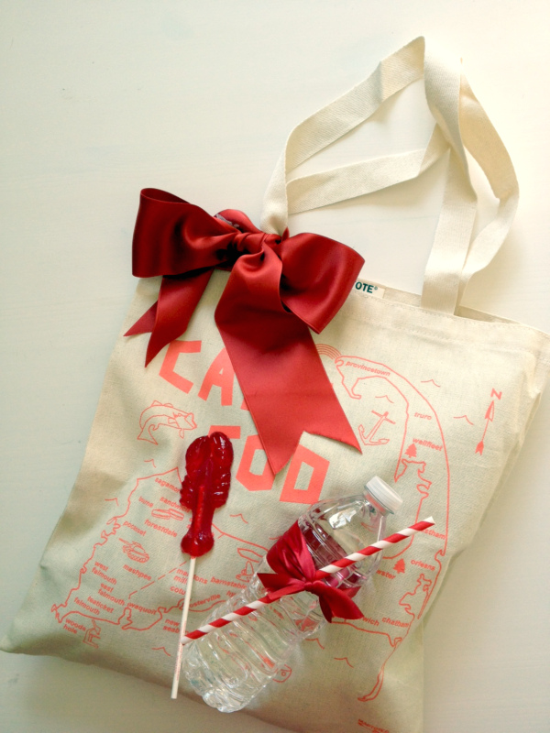 Gift bag with red bow, water bottle, and candy