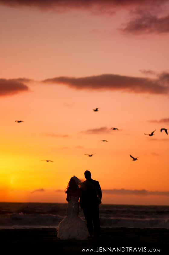 Bride and groom at sunset beach wedding with birds