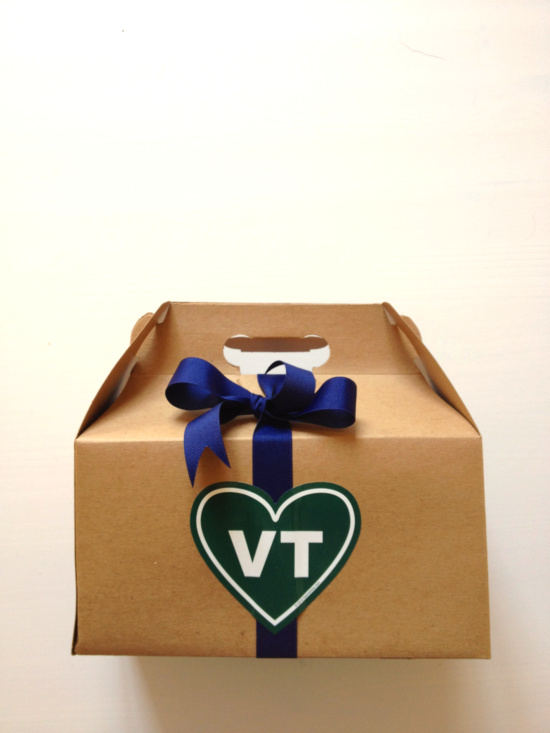 Gift box with a navy bow and Vermont heart logo