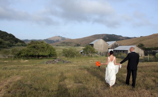 Rustic wedding couple walking in scenic countryside