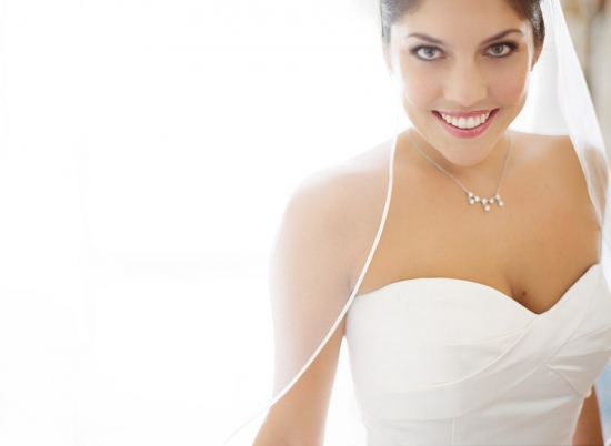 Happy bride in a white dress and veil smiling
