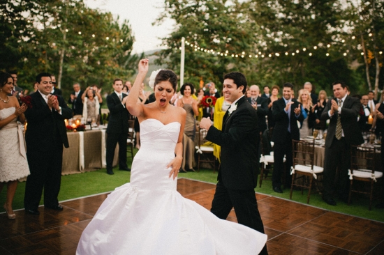 Bride and groom dancing joyfully at outdoor wedding