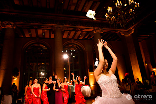 Bride tossing bouquet at wedding reception