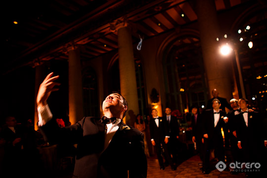 Groom tossing garter at wedding