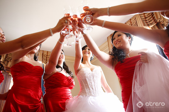 Bridesmaids toast bride in red dresses