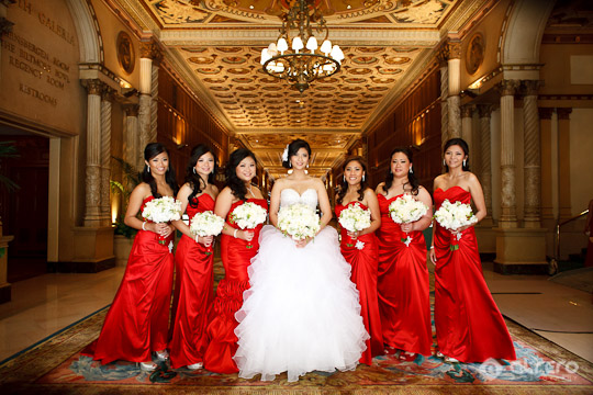 Bride and bridesmaids in red gowns at wedding