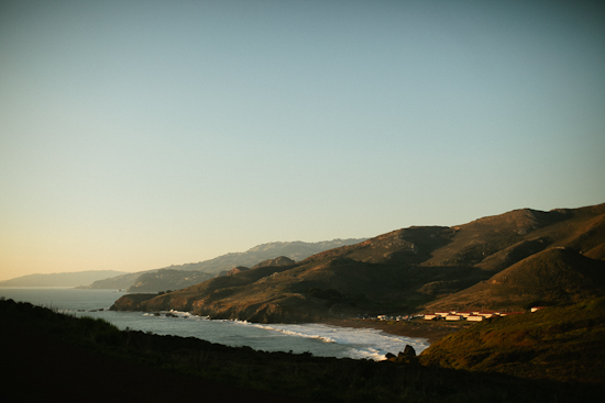 Coastal hillsides at golden hour with small ocean waves