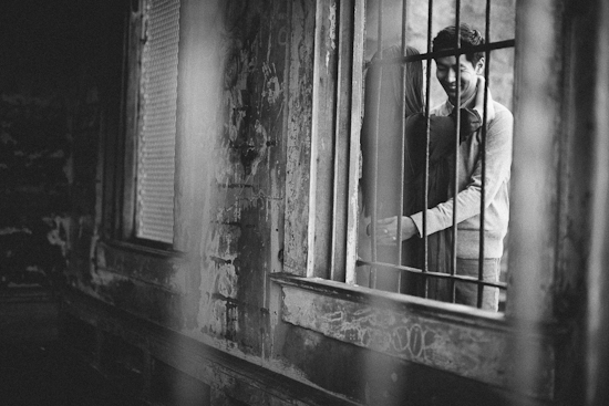 Black and white photo of smiling man behind bars
