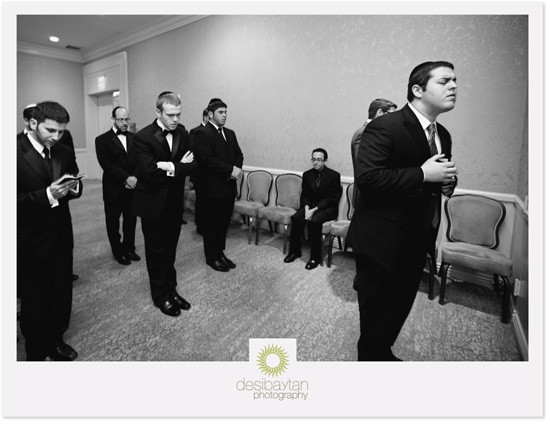 Groomsmen in suits waiting prayerfully before ceremony