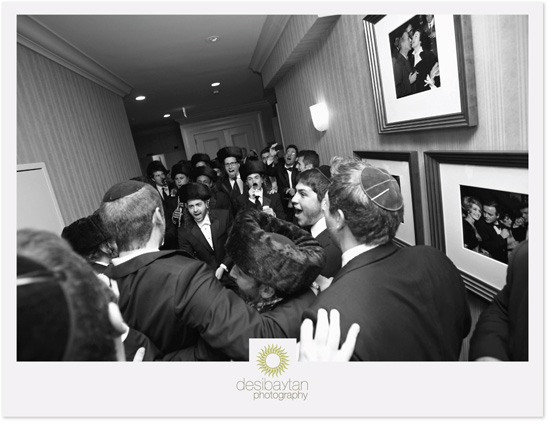 Jewish wedding guests joyfully celebrate in hallway