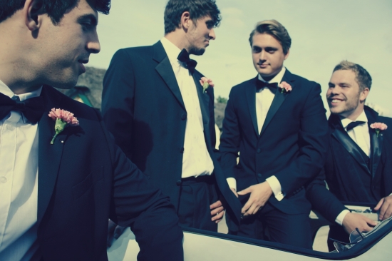 Groomsmen in tuxedos pose for a wedding photo
