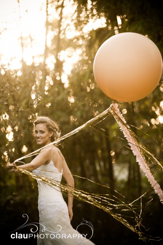 Bride with a large balloon in a sunny outdoor wedding