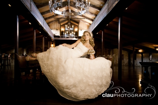 Bride in gown at rustic wedding venue with chandelier