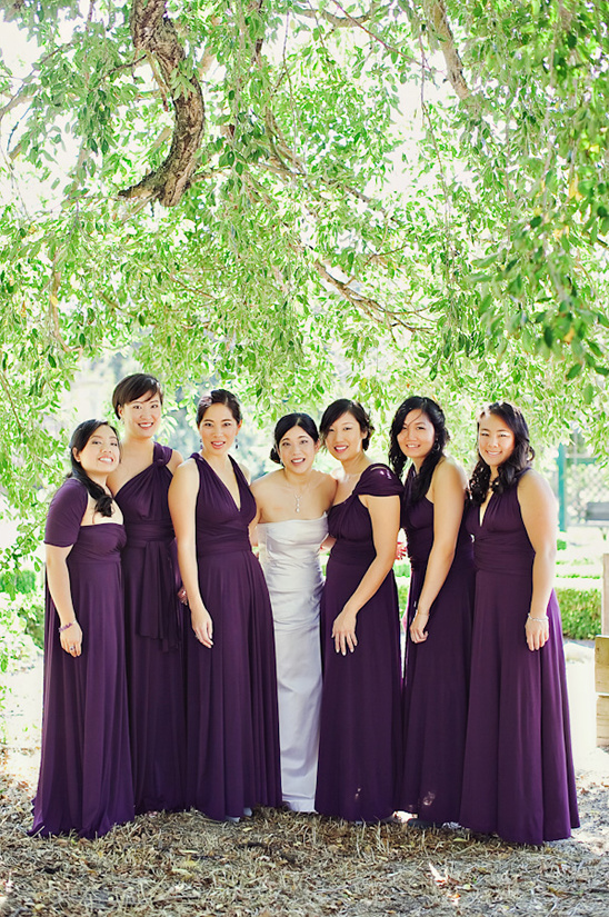 Bridesmaids in purple infinity dresses under a tree