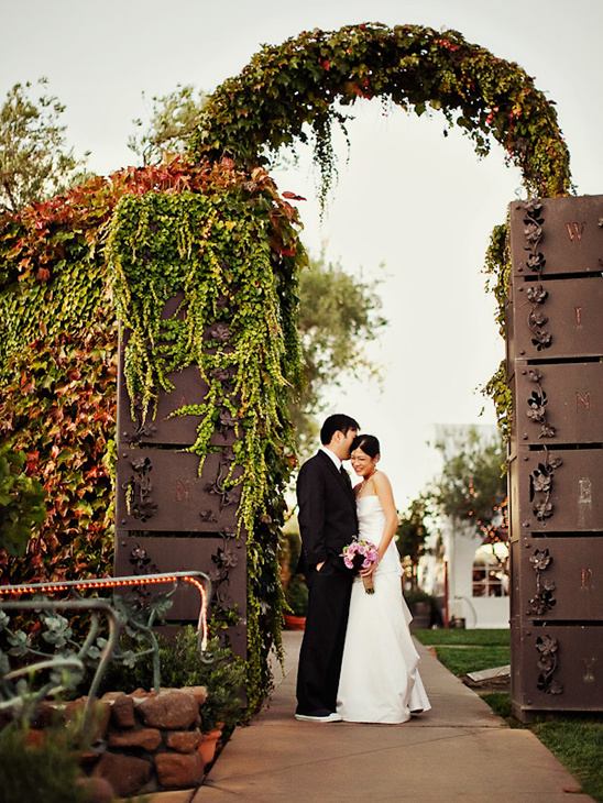 Happy couple embracing under a vine-covered arch
