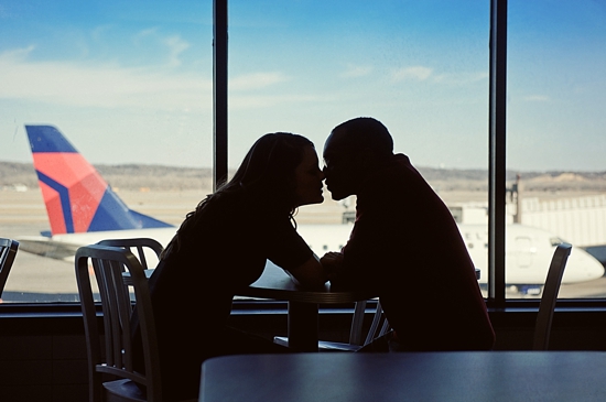Silhouette couple kissing airport window